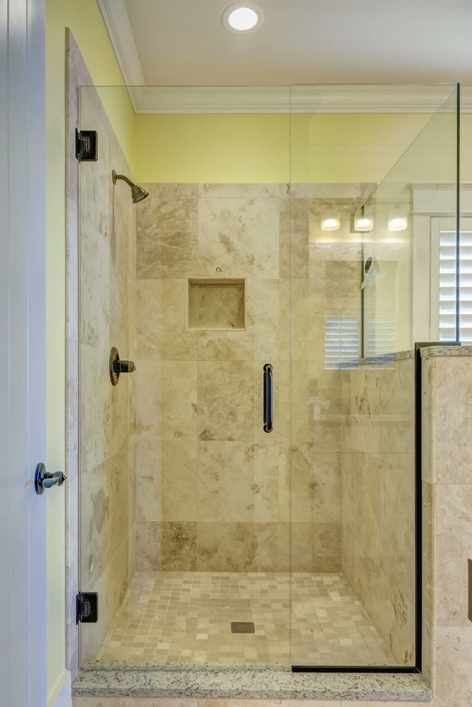 Tiled walk-in shower with a glass door in a remodelled bathroom