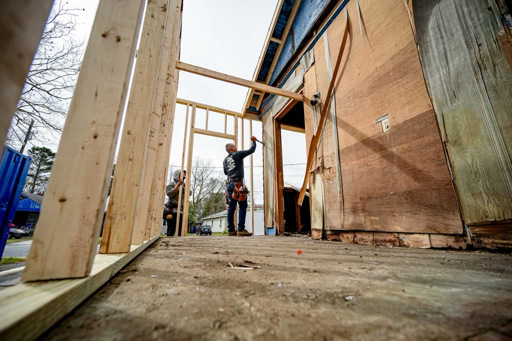 Carpenter framing a new opening inside an old timber building